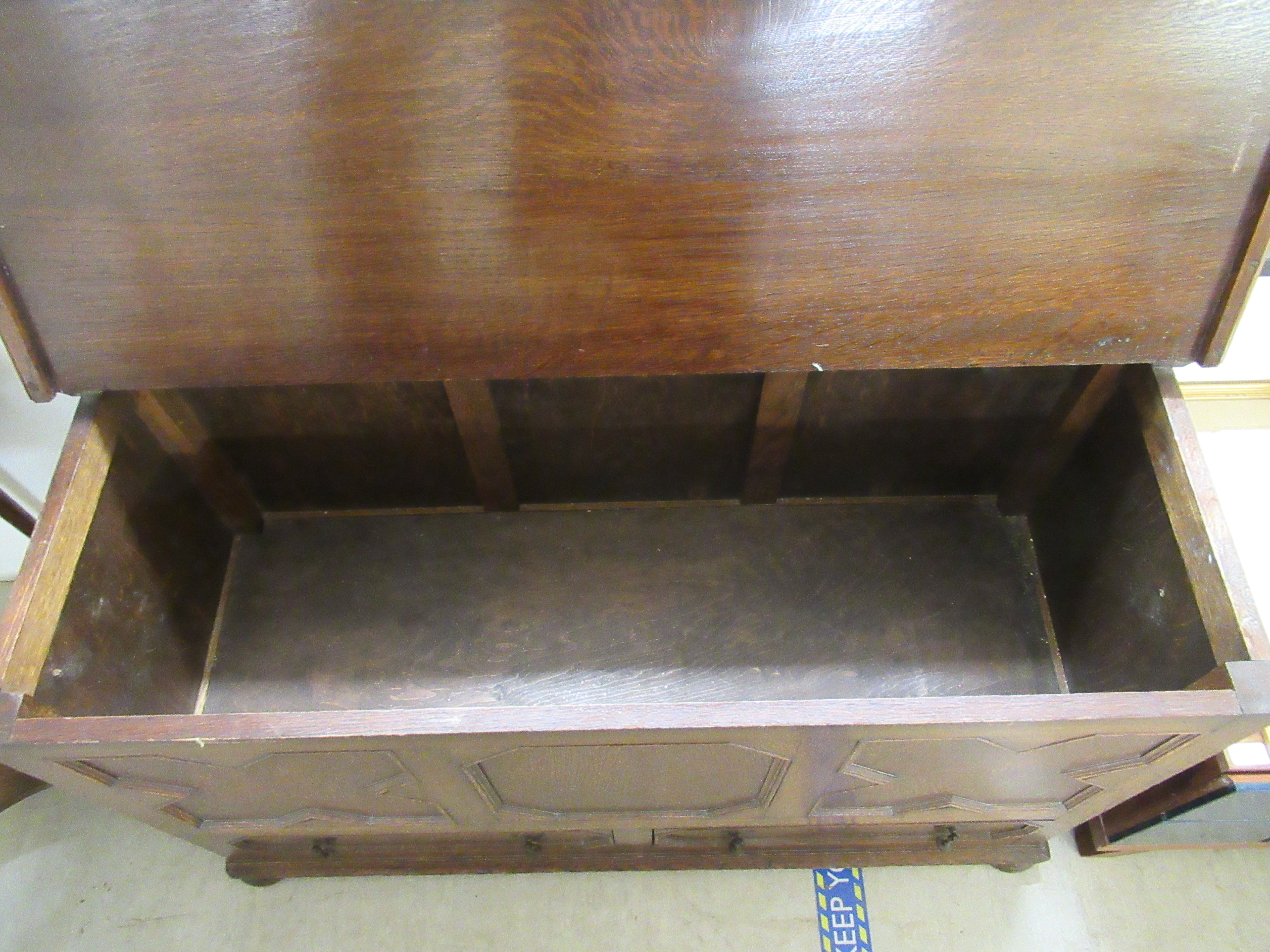 A 1930s oak mule chest with a hinged lid, over a tri-panelled front and two base drawers, - Image 3 of 4