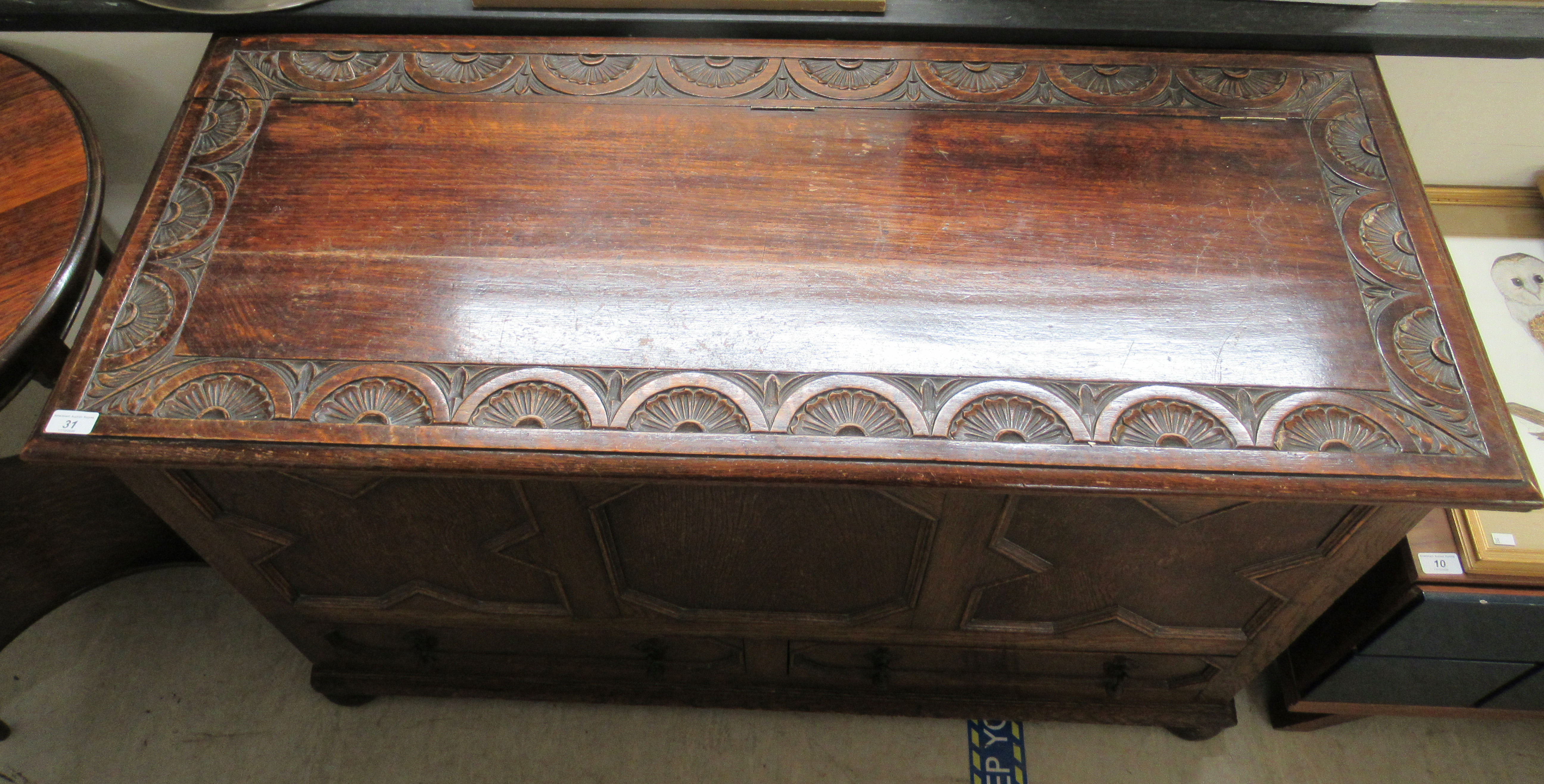 A 1930s oak mule chest with a hinged lid, over a tri-panelled front and two base drawers, - Image 2 of 4