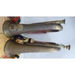 Two military style brass bugles with multi-coloured cords and tassels,