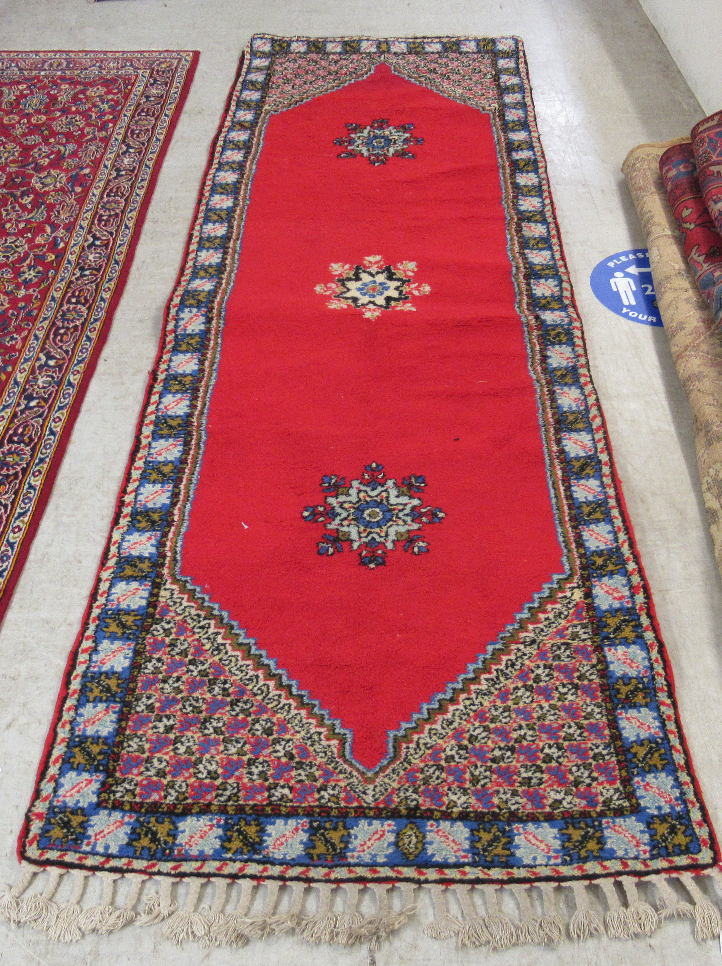 A Persian runner with opposing tasselled ends and three central starburst motifs,