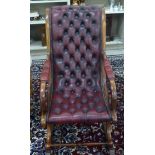 A Victorian style mahogany framed rocking chair with open, scrolled arms,