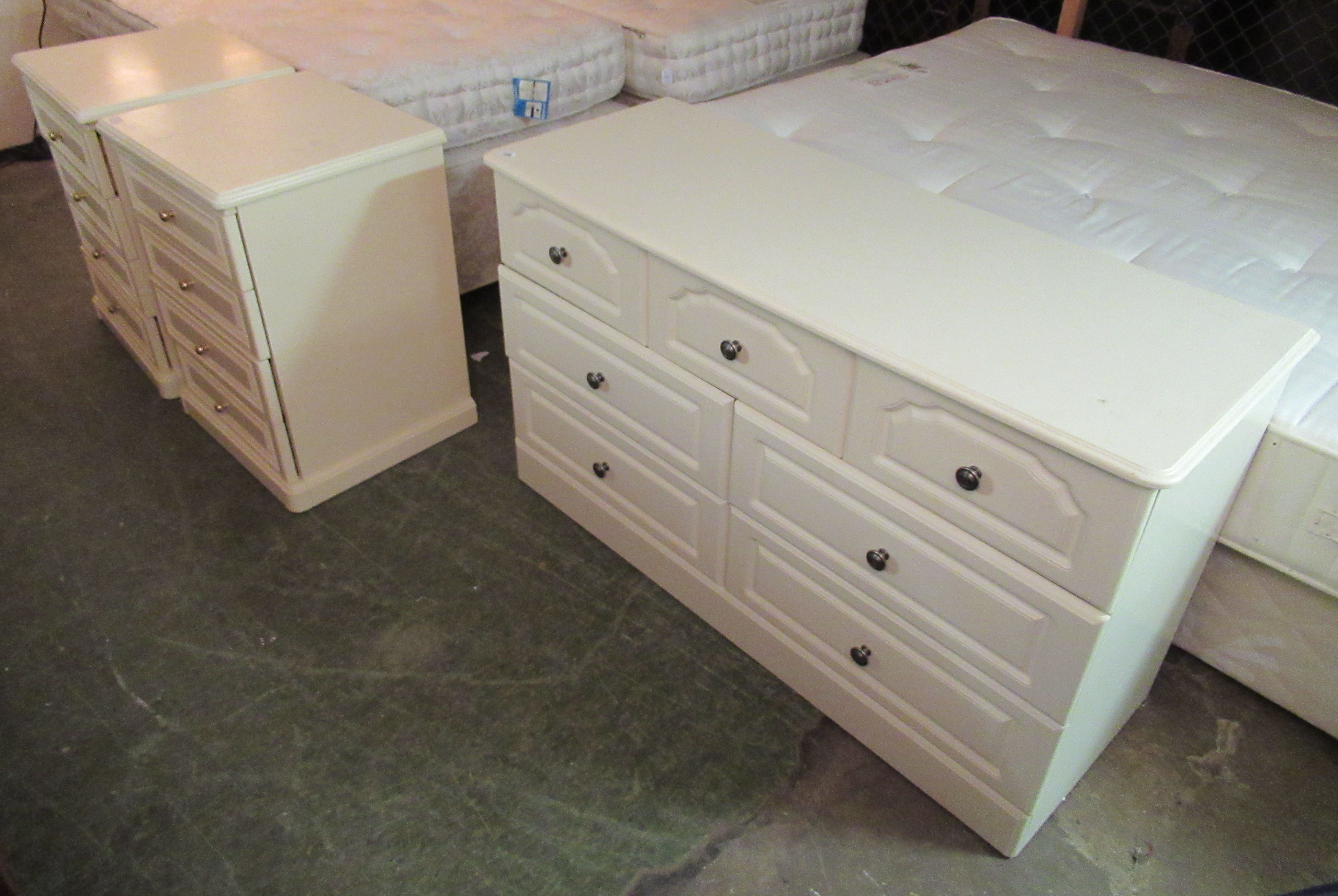 A pair of modern cream coloured laminated four drawer bedside chests 27''h 21''w;