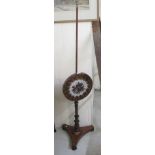 A Regency mahogany framed height adjustable polescreen with a fretcarved and beadworked floral