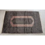 A Persian rug with a central elongated hexagonal motif, bordered by stylised designs,