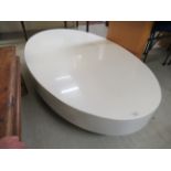 A modern white laminate oval coffee table,