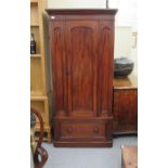 A late Victorian mahogany wardrobe with a single three-quarter height door and a base drawer,