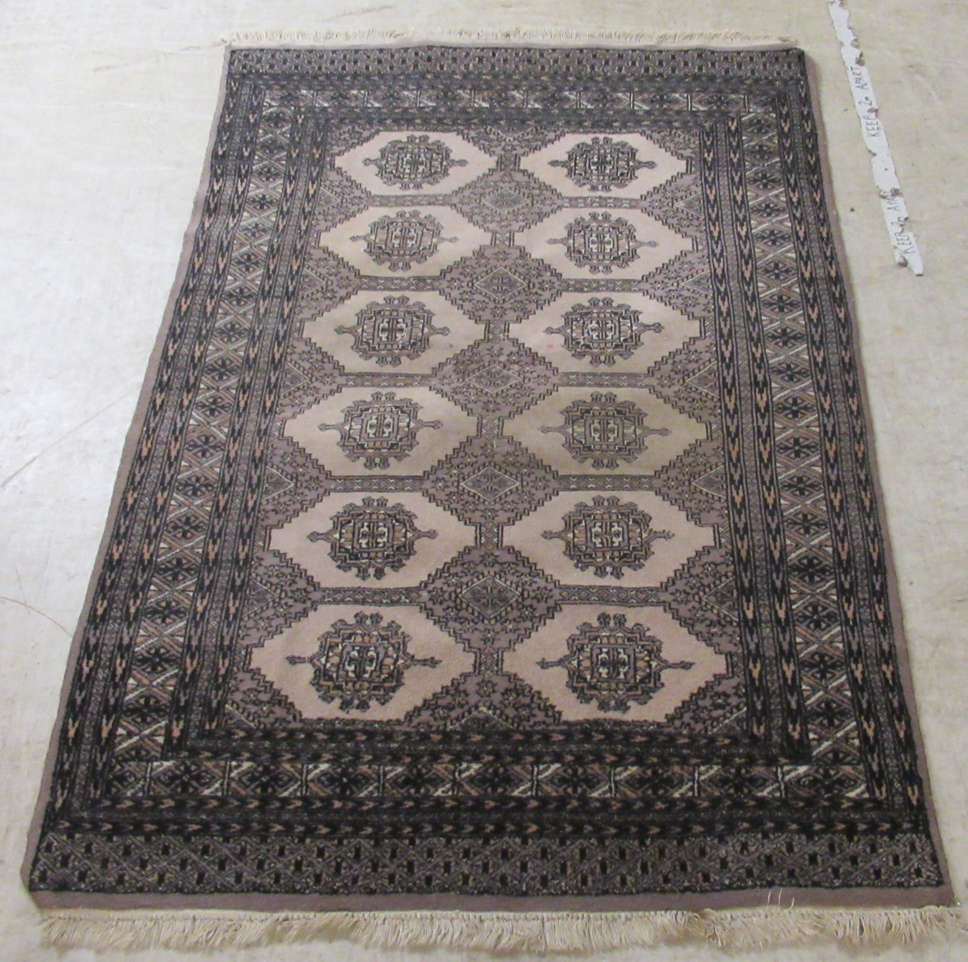 A Bokhara rug, decorated with two columns of six hexagonal guls,