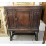 A 1930s oak hall cabinet with a single panelled door, raised on turned,