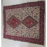 A Middle Eastern inspired rug, decorated with stylised birds and other animals,