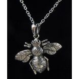 A silver articulated bee pendant,