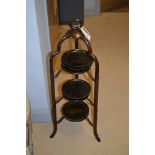 Three-tier cake stand; and four black cake plates.