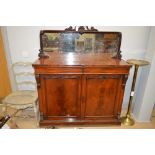 A Victorian mahogany chiffonier, the mirror panel back with ornately carved surround, fitted two