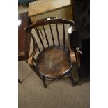 An Edwardian spindle back arm chair, the yoked top rail above spindle spars and outswept arms and