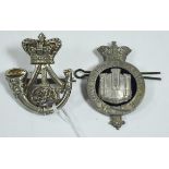 Two cap badges