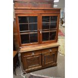 A 20th century mahogany dresser base with an associated pine bookcase top. the top with two astragal