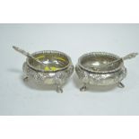 A pair of silver table salts and spoons