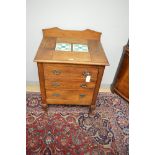 An Arts & Crafts style oak washstand, with shaped gallery and tile inset top, above three long