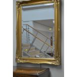 A gold painted picture frame wall mirror.