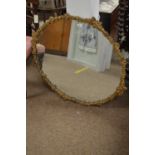 Ornate brass framed oval wall mirror.