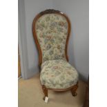 A Victorian carved walnut high back nursing chair, with carved scrollwork detail, buttoned