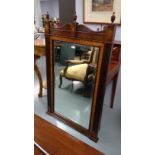 A 20th Century mahogany and satinwood mirror, with arched top surmounted with finials and inlaid