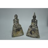 A pair of white metal mounted buddha statues