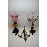An oil lamp; chandelier; and table lamp.