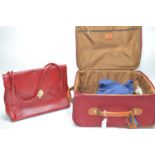 Red leather bag; and a red trolley/overnight case.