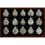 A collection of 20th Century Police helmet badges, framed.