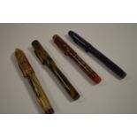 Four fountain pens in marbled cases