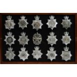 A collection of 20th Century Police helmet badges, framed.