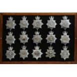 A collection of 20th Century Police helmet badges, framed.