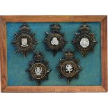 A collection of 20th Century Police helmet badges, framed.