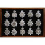A collection of 20th Century Police helmet badges, framed.