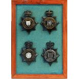 A collection of 20th Century Police helmet badges, framed.