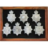 A collection of 20th Century Police helmet badges, framed.