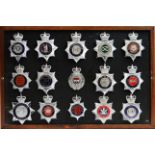 A collection of 20th Century Police helmet badges, framed.