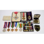 A collection of medals, badges and ribbon bars.