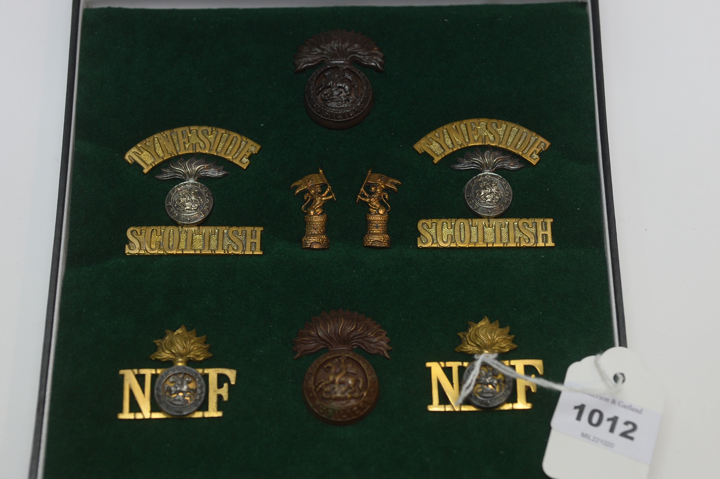 A collection of regimental cap badges