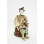 A late 19th/early 20th Century Chinese opera doll; and a wicker chair.