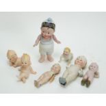 Two German and one bisque Kewpie piano-baby dolls; and five others, various.