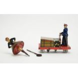 A tinplate flywheel Scottish dancer; and a Post War German clockwork luggage trolley.