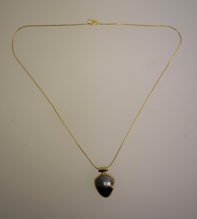 A 9ct yellow gold pendant set with black mabe pearl