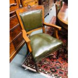 A set of seven walnut framed green leather chairs