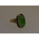 A yellow metal ring set with oval green hardstone