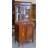 A mahogany inlaid Sheraton style corner cabinet with a pair of glazed doors over panelled