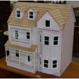 A large pale pink painted wooden doll's house