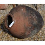 A weathered terracotta oil jar