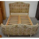 A French carved walnut double bed frame with floral padded head and foot boards