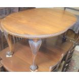Mahogany extending dining table, pie crust top with single central leaf raised on carved cabriole